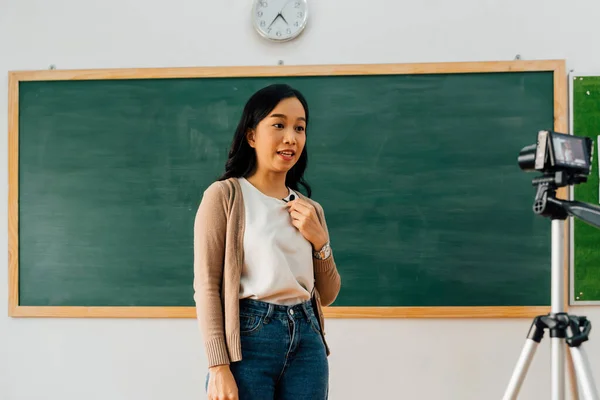 Asian school teacher delivering online course