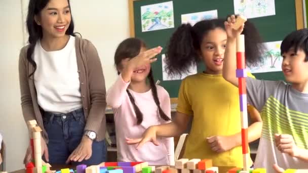 Niños jugando con bloques de madera en el aula — Vídeo de stock