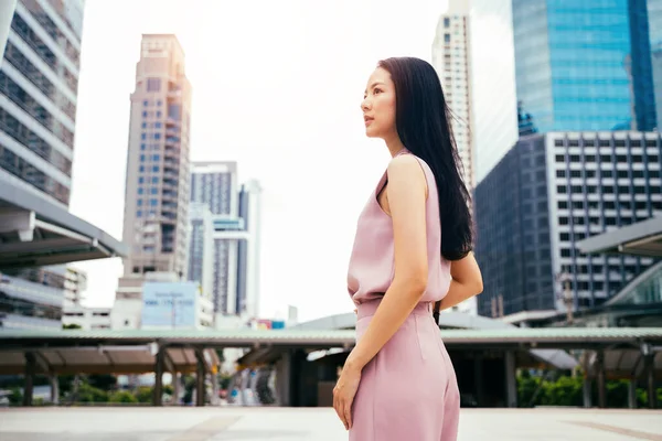 若い大人の女性の背の高い近代的な建物、頭と肩を持つ都市に向かって探しているビジネスマン女性. — ストック写真