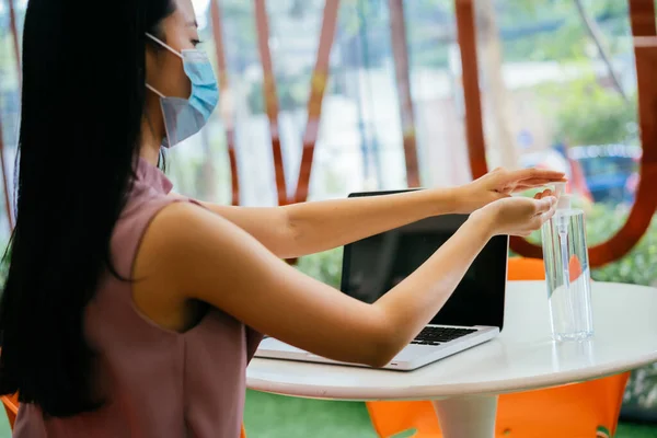 Mulher de negócios asiática usando máscara facial usando laptop no escritório — Fotografia de Stock