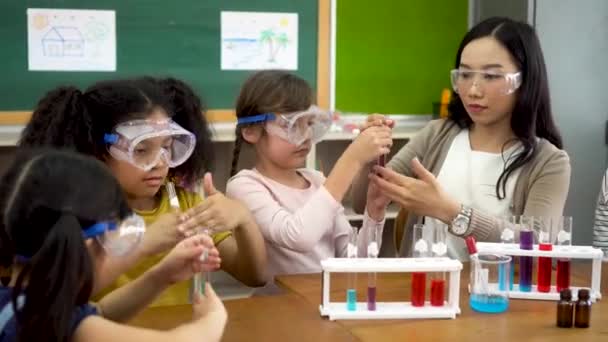 Учитель азиатских школ и студенты в классе естественных наук — стоковое видео