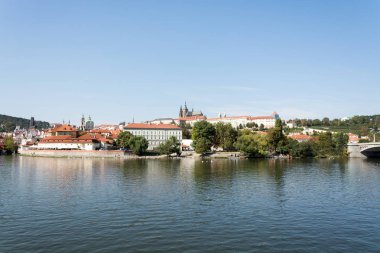 Prag, Çek Cumhuriyeti'nde, parlak bir yaz gününde Vltava Nehri'nin sahil panoraması, New Town ve Petrin gözetleme kulesinin renkli çatıları
