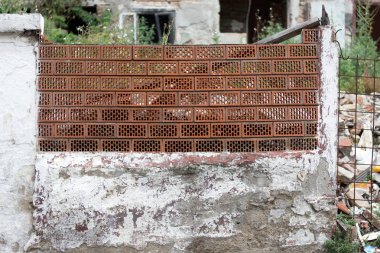 Bulanık ev harabesi önünde, grungy eski çimento sıva duvar üzerinde Içi boş tuğla şeffaf çit 