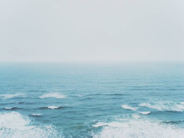 Ufukta soluk gökyüzüne ulaşan turkuaz okyanus 