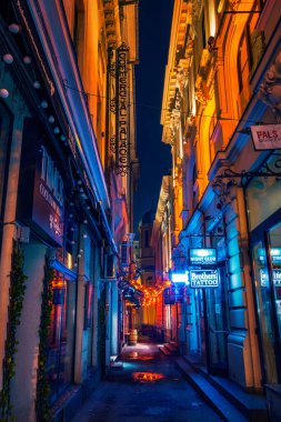 Beautiful narrow alley with night clubs and cocktail bars shot in the night downtown in Bucharest city clipart
