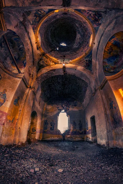 Stunning tall ruin on a church collapsing shot from interior with saints painted on the walls and holes in the ceiling shot with a fisheye lens