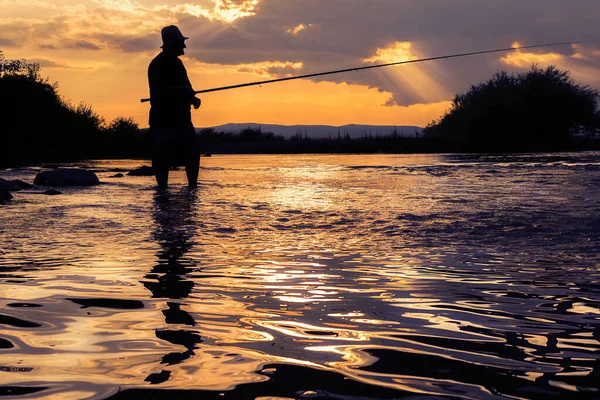 Silueta Pescador Pie Agua Con Caña Atardecer Con Cuerpo Reflejándose —  Fotos de Stock