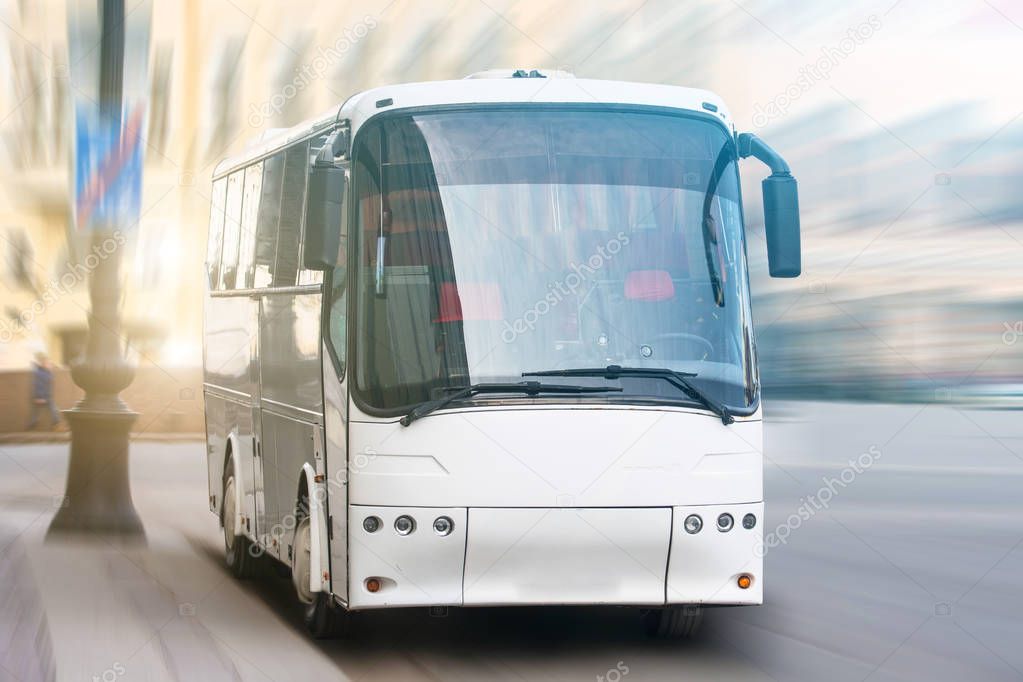 Modern transport bus on asphalt rides at high speed, front view