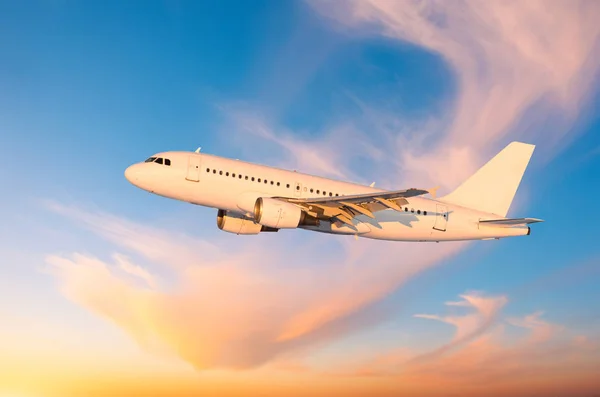 日没時に巻雲 胴体に翼から影の背景で空を飛ぶ旅客機 — ストック写真