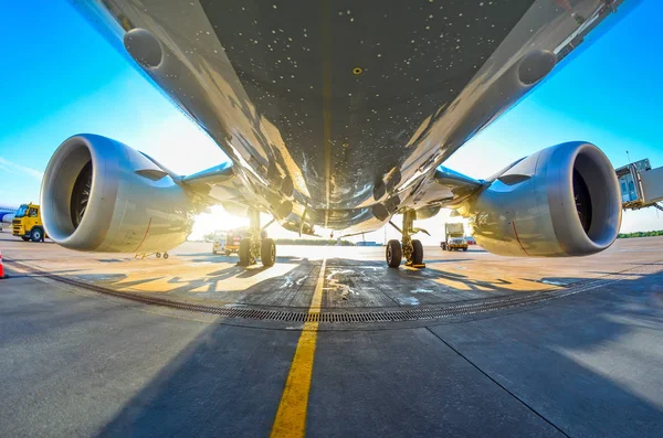 Airplane in the parking lot of the airport apron, bottom view hdr of engines, fuselage and wings