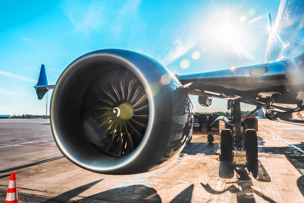 Aircraft is parked at the airport before departure, the view on the wing of the chassis rack gear engine, on the sunny day with a glare and light