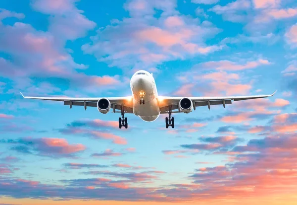 飛行機が飛んで明るい赤い日没 Cloudscape 中の夕方の着陸滑走路空港に到着 — ストック写真