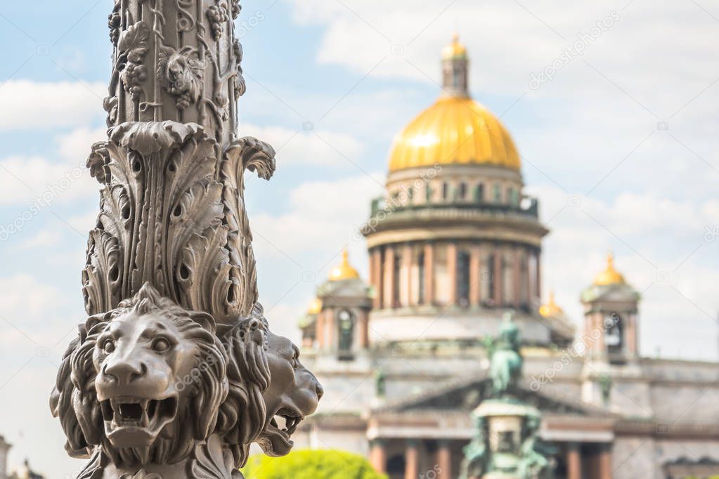 Saint Isaac's Cathedral out of focus, in the foreground the sculpture of lions on a pillar. Saint-Petersburg, Russia