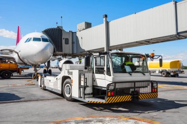 Uçak geri sepeti çekici traktör kasanın ön iniş takımı üzerinde bastırıyor.