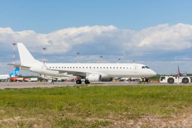 Uçak geri sepeti çekici traktör kasanın ön iniş takımı üzerinde bastırıyor.