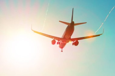 Renk gökkuşağı gradyan ile bir buhar jeti girdap wings açılış ile güneş parlamayı yakınındaki yolcu uçak uçar