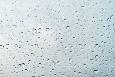 Gri bulutlu gökyüzü karşı bir bardak su damlaları