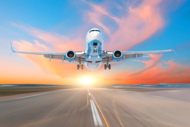 Airplane take off from runway airport in the evening at sunset, the sky and picturesque clouds clipart