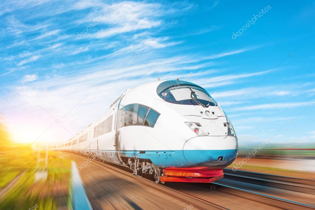 High speed fast train passenger locomotive in motion at the railway station beautiful picturesque blue sky