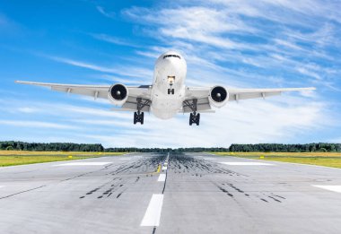 Mavi gökyüzü ile iyi açık havada bir piste iniş yolcu uçak