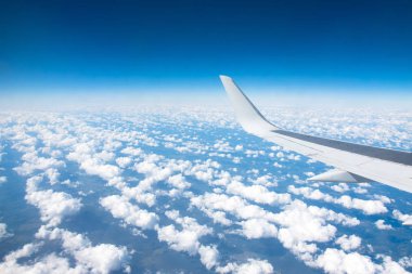 Kanatçıklar ve jet motoru üzerinde uçağın kanat görüntüsü, uçuş seviyesi boyunca ufuk çizgisinde kabarık bulutlar.