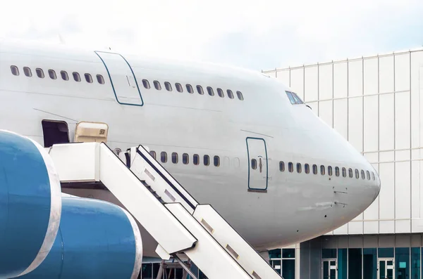 Large airplane before departure for a flight in the parking lot at the airport against the backdrop of a passenger terminal