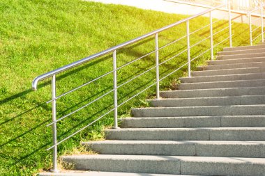 Çim çimen, metal parlayan ve korkuluk ile yukarı taş merdiven