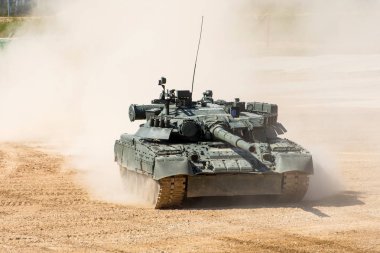 Güçlü askeri tank tozlu alan boyunca yüksek hızda sürmek