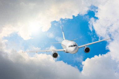 Uçak uçar yüksek gökyüzü, bulutlar ve güneşli bir parlama üzerinden bir yolculuk