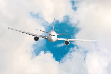 Yolcu uçağı bir yüksekliği yukarıda mavi gökyüzü ve bulutlar üzerinde