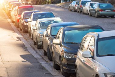 Çok araba park edilmiş ve kentsel Caddesi üzerinde ağaçların altında dizilmiş