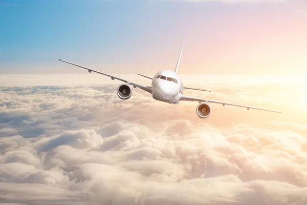 鮮やかな夕焼け色に雲地平線空上空を飛んでいる旅客機 — ストック写真