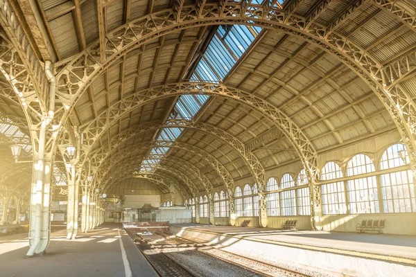 Architecture curved arches, metal struts and glass roof, interior details at empty train station.