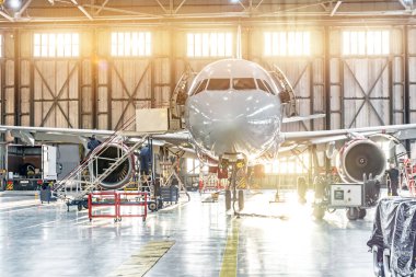 Passenger aircraft on maintenance of engine repair in airport hangar clipart