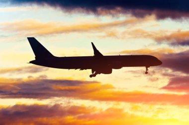 Akşam günbatımında pitoresk bir gökyüzü zemin karşı karanlık bir siluet uçak benziyor