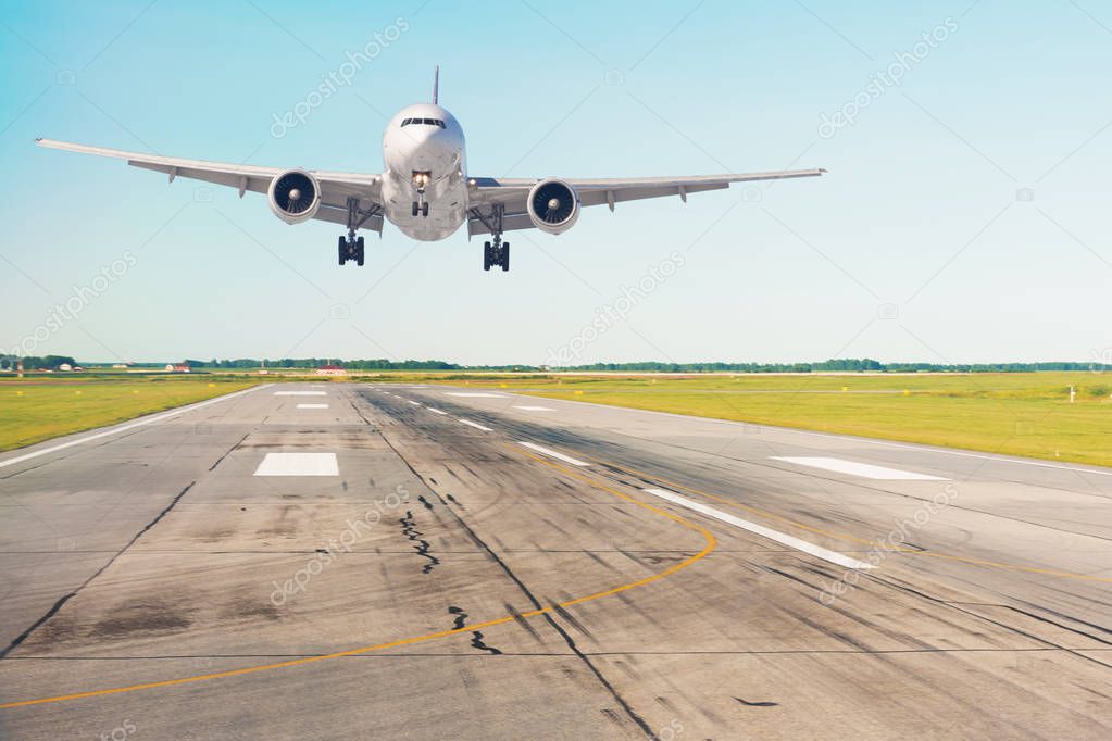 Landing plane on the runway in strong winds at the airport.