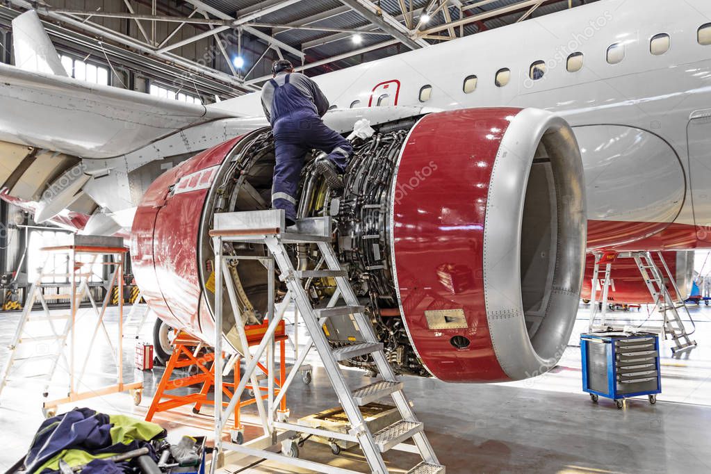 Aviation industry, mechanic repairs aircraft engine jet.