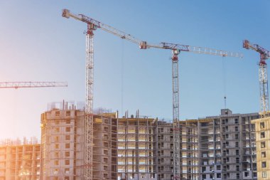 Katı beton ve tuğlalardan konut inşaatı. Yüksek binaların ve vinçlerin manzarası.