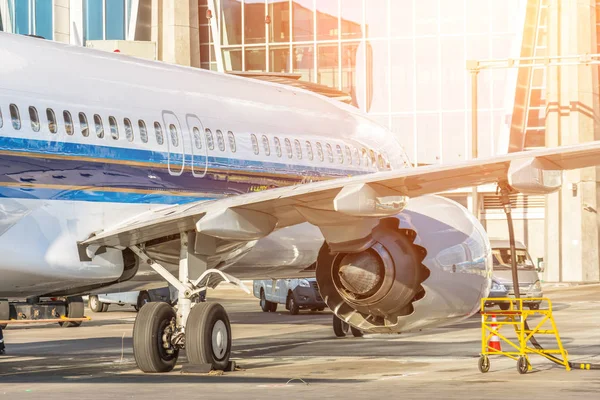Avión de pasajeros está estacionado en frente de la terminal para el mantenimiento y repostaje antes del vuelo — Foto de Stock