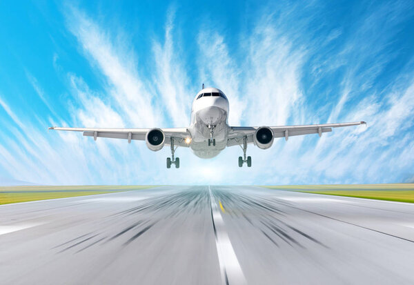 Взлетно-посадочная полоса с эффектом размытия движения скорости, самолет приземляется на голубое небо с облаками
