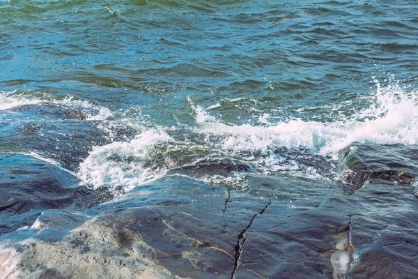 Salpicaduras de las olas chocando contra la costa rocosa — Foto de Stock