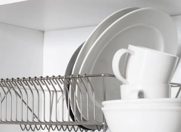 Kitchen cupboard with a lattice for dishes, with a white and black plate, cups