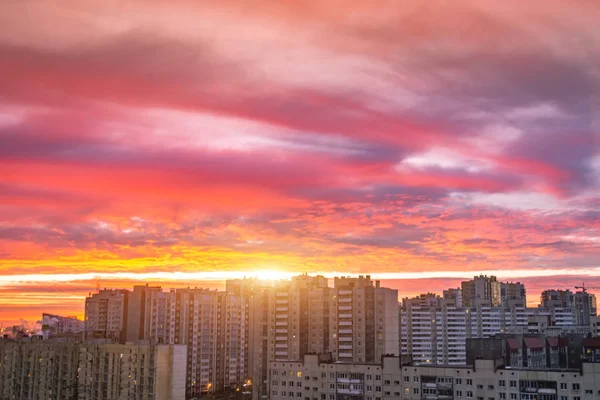 Lever de soleil lumineux nuages roses rouges sur les immeubles résidentiels de grande hauteur à l'horizon . — Photo