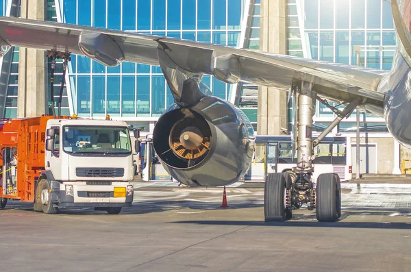 Proceso de repostaje de aeronaves. Vista del camión, el ala del motor y el chasis . — Foto de Stock