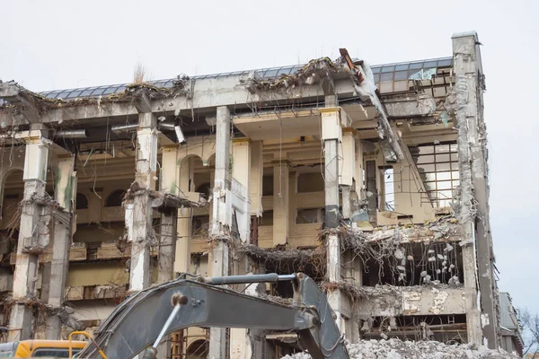 Demolition and destruction of a building using excavator. Destroyers equipment.