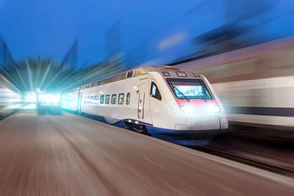 Nacht treinstation, een passerende trein op snelheid. — Stockfoto