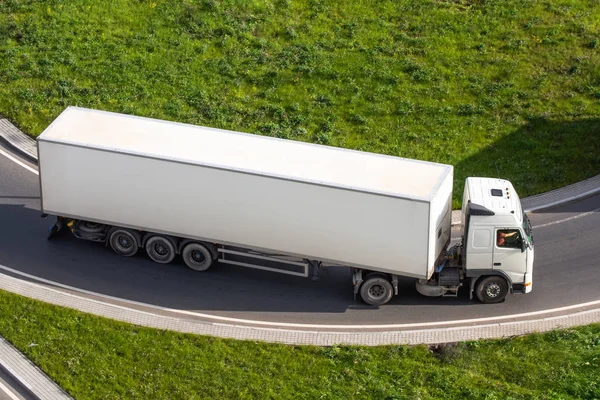 Truck met een witte aanhangwagen aan het begin van de snelweg. — Stockfoto