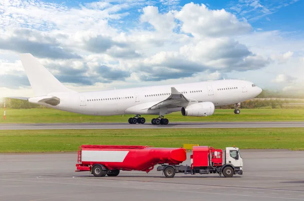 Avión despegue de la pista en el aeropuerto, en primer plano un camión con un tanque de combustible de aviación . — Foto de Stock