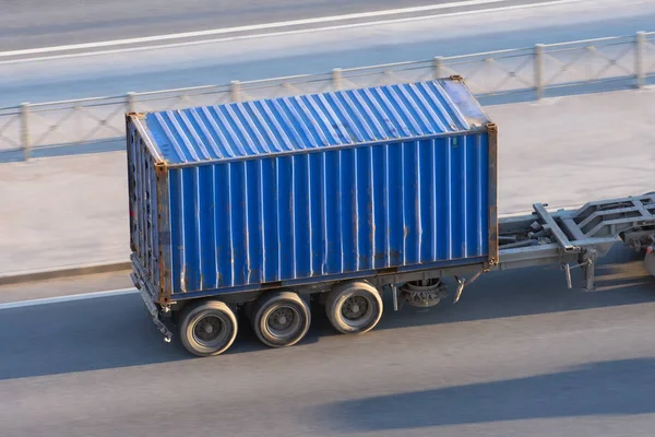 Blauwe container trailer rijden op een snelweg op hoge snelheid. — Stockfoto