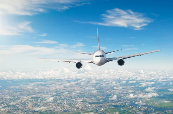 Passenger airliner flies over the city, a decline in airport arrival. — Stock Photo, Image